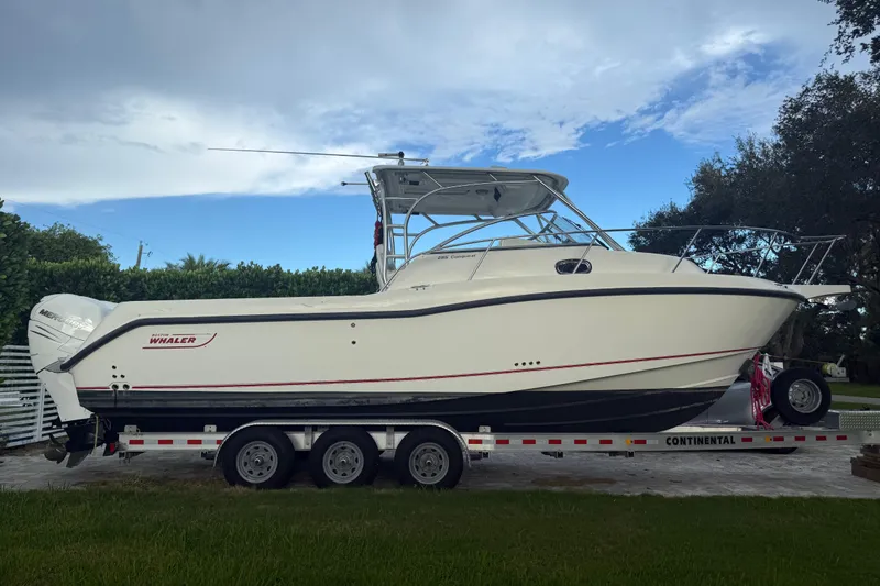The Image of 2011 Boston Whaler 285 Conquest boat on trailer under blue sky. - 0