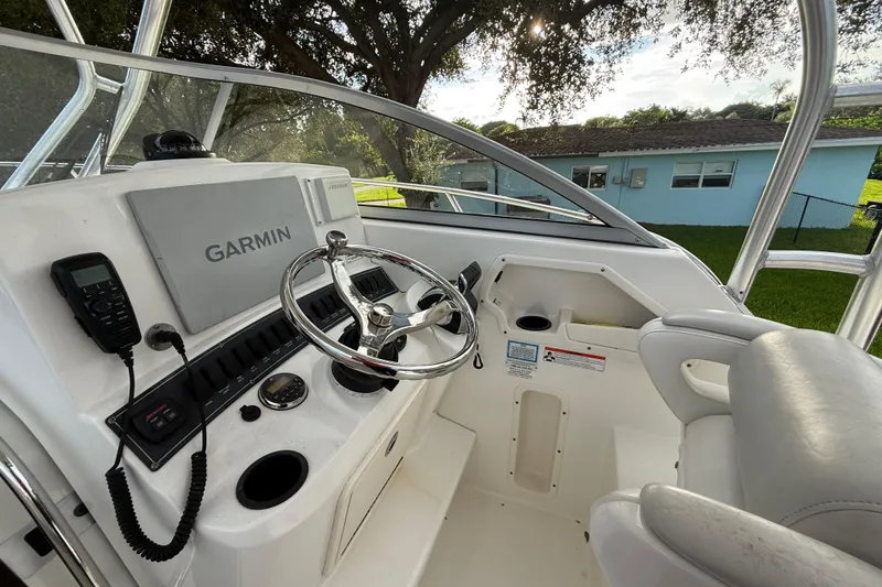 Slide: The Image of 2011 Boston Whaler 285 Conquest boat interior with coiled blue hose and storage compartment. - 22