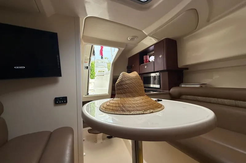 Slide: The Image of Interior of 2011 Boston Whaler 285 Conquest with seating, table, and kitchenette. - 25