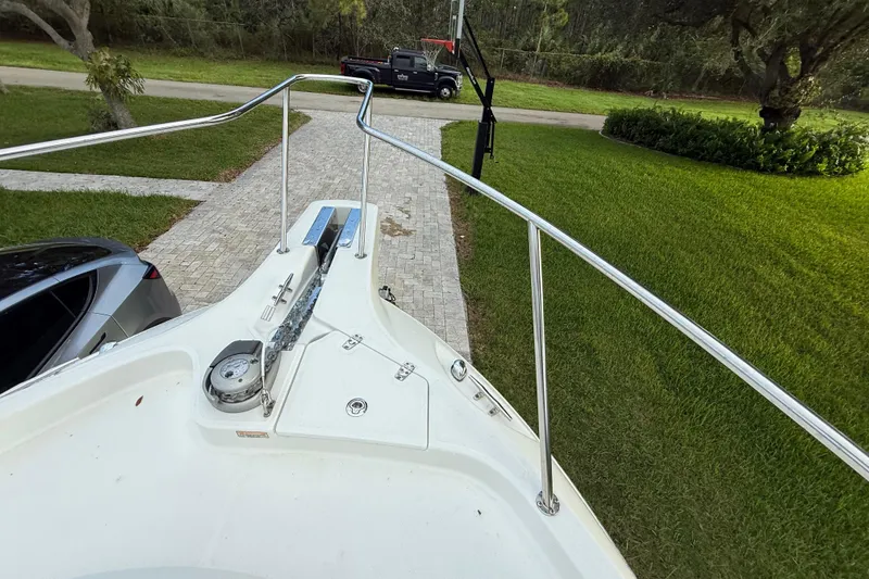 Slide: The Image of 2011 Boston Whaler 285 Conquest boat on driveway, surrounded by trees and vehicles. - 40