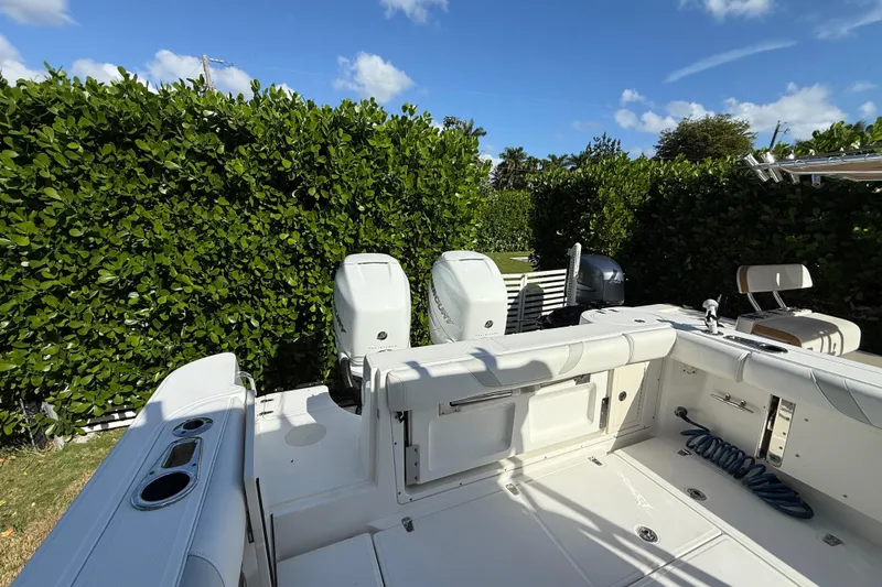 Slide: The Image of 2011 Boston Whaler 285 Conquest boat deck with dual engines, surrounded by lush greenery. - 6