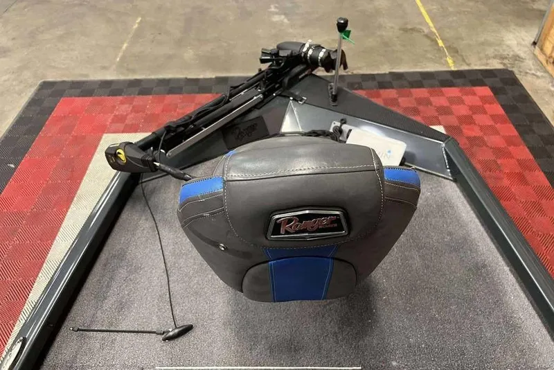 Slide: The Image of 2022 Ranger RT178 boat seat and controls on checkered floor. - 2