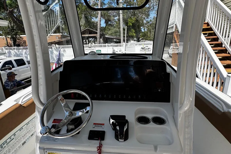 Slide: The Image of 2022 Sea Hunt Ultra 255 SE boat interior with brown seating, on calm water. - 10