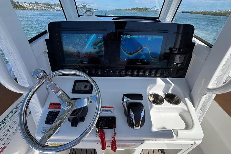 Slide: The Image of 2022 Sea Hunt Ultra 255 SE boat dashboard with navigation screens and steering wheel. - 12