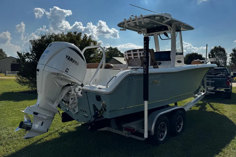 Slide: The Image of 2022 Sea Hunt Ultra 255 SE boat on water near docks and trees. - 6