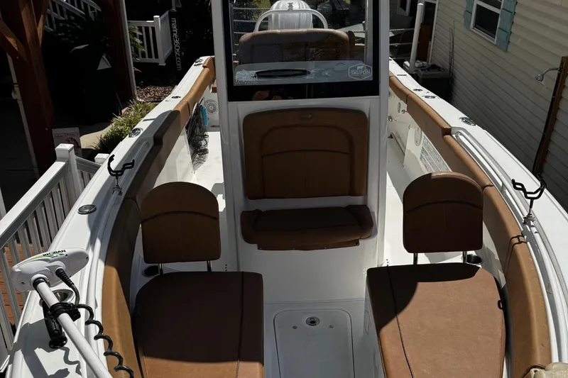 Slide: The Image of 2022 Sea Hunt Ultra 255 SE boat cruising near a marina with blue-roofed buildings. - 7