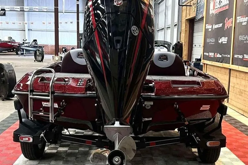 Slide: The Image of 2026 Ranger Z185 boat in showroom, rear view with powerful outboard motor. - 2
