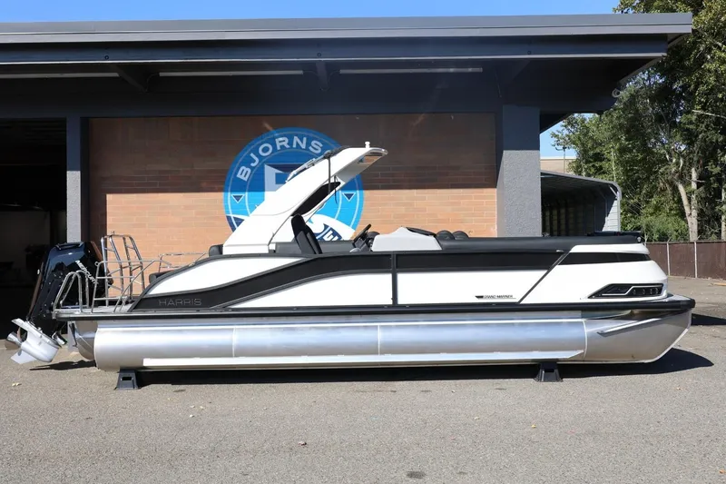 Slide: The Image of 2026 Harris Grand Mariner 250 pontoon boat parked outdoors. - 1