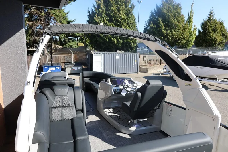 Slide: The Image of 2026 Harris Grand Mariner 250 pontoon boat on trailer, parked outdoors. - 54