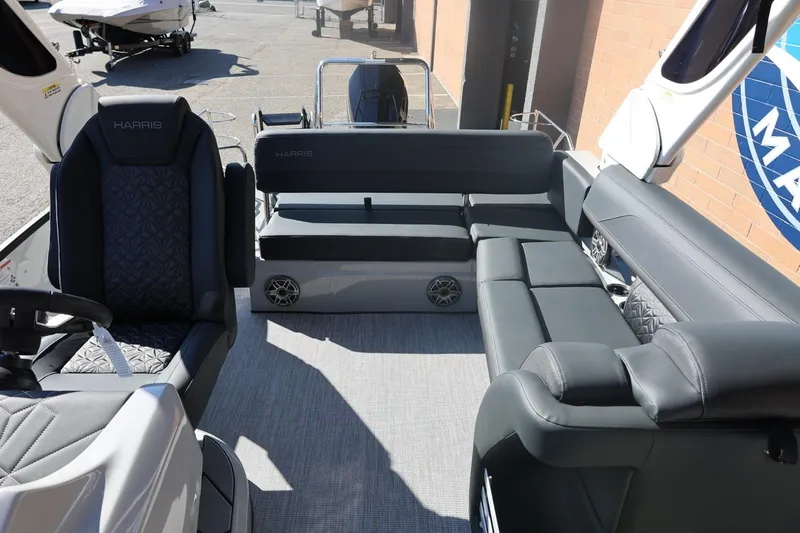 Slide: The Image of 2026 Harris Grand Mariner 250 pontoon boat on trailer, sleek design, parked outdoors. - 56