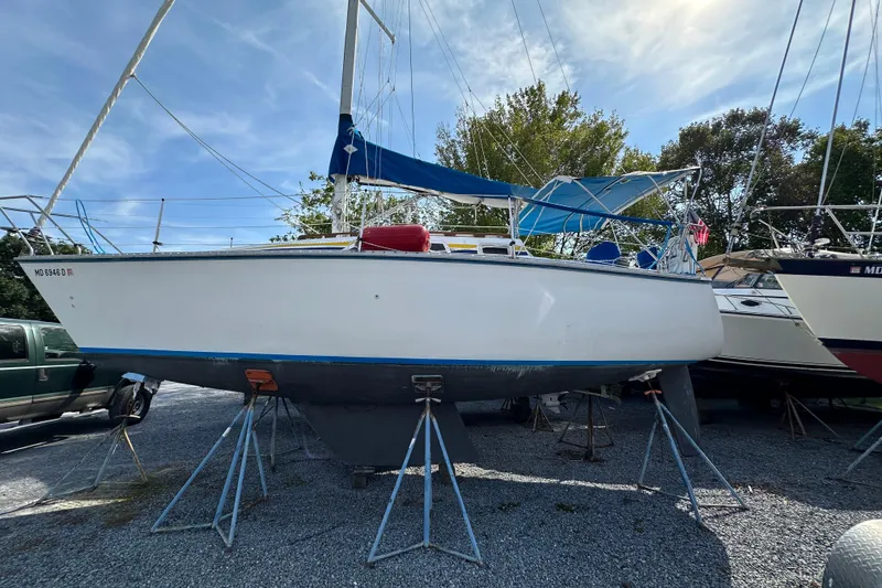 The Image of 1985 Hunter 28.5 sailboat on stands, blue trim, outdoor storage. - 1
