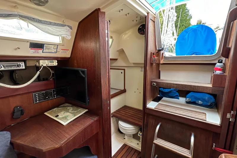 Slide: The Image of Interior of a 1985 Hunter 28.5 sailboat with navigation station and compact bathroom. - 12
