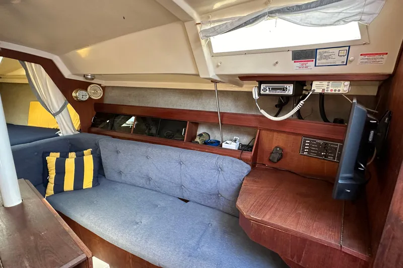 Slide: The Image of Interior of 1985 Hunter 28.5 sailboat with blue sofa and nautical decor. - 13