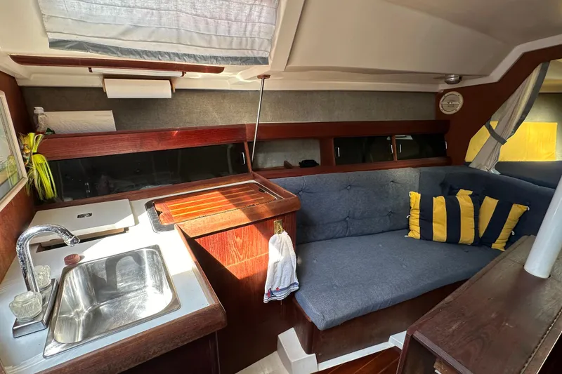 Slide: The Image of Interior of 1985 Hunter 28.5 sailboat with cozy seating and compact kitchen area. - 14