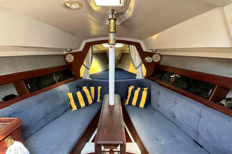 Slide: The Image of Interior of 1985 Hunter 28.5 sailboat with blue seating and striped pillows. - 15