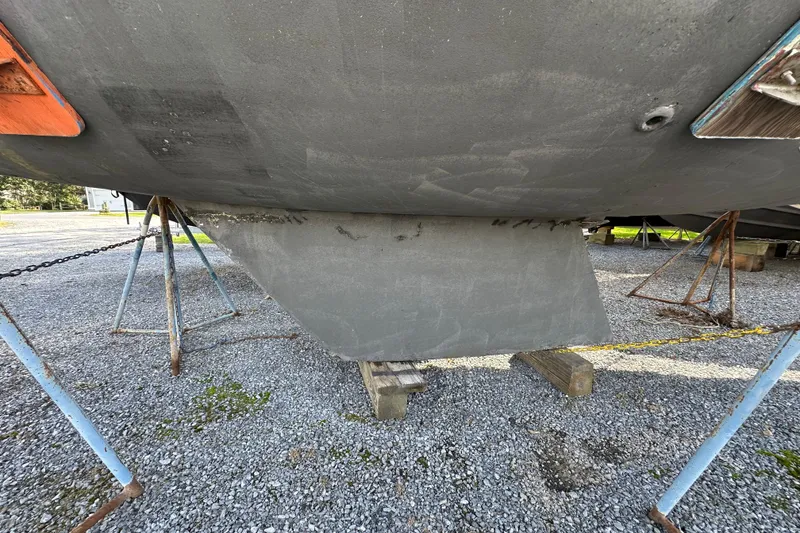 Slide: The Image of 1985 Hunter 28.5 sailboat keel on gravel, supported by stands. - 16