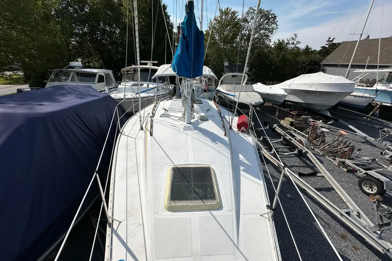 Slide: The Image of 1985 Hunter 28.5 sailboat on land, surrounded by other boats and trailers. - 3
