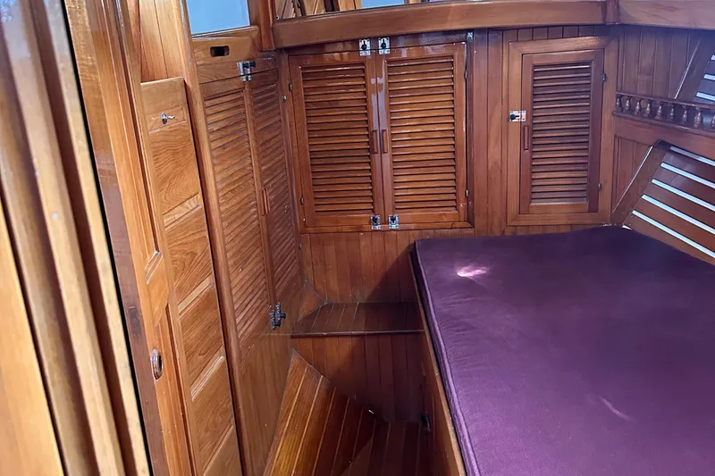 Slide: The Image of 1978 Tayana Mariner cabin interior with wooden paneling and purple mattress. - 13