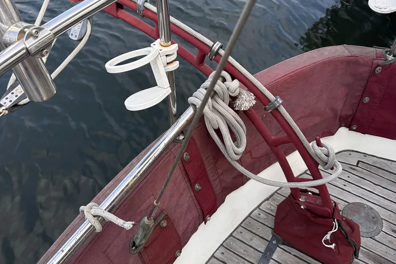 Slide: The Image of 1978 Tayana Mariner sailboat deck with red canvas, ropes, and stainless steel fittings. - 16