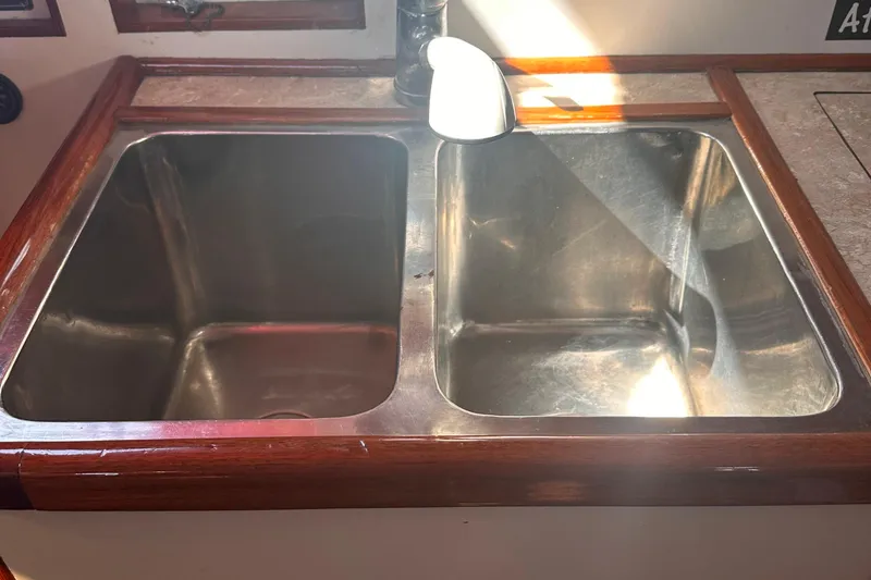 Slide: The Image of Stainless steel double sink on 1978 Tayana Mariner yacht with wooden trim. - 19