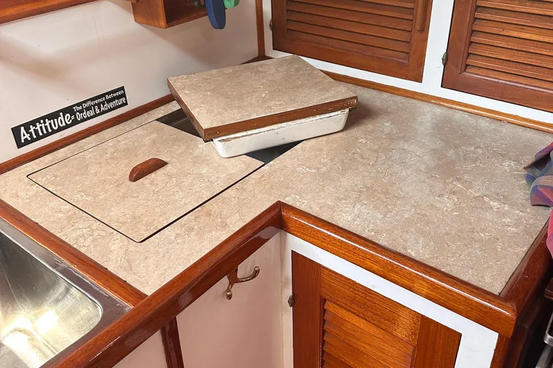 Slide: The Image of 1978 Tayana Mariner kitchen with wooden cabinets and beige countertops. - 20