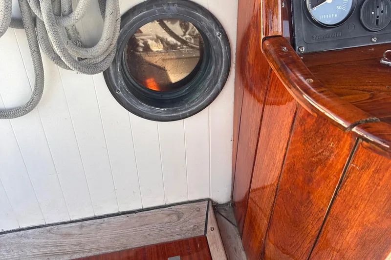 Slide: The Image of 1978 Tayana Mariner interior with wooden paneling, porthole, and coiled rope. - 25