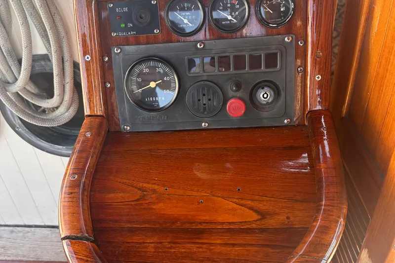 Slide: The Image of Control panel of a 1978 Tayana Mariner boat with gauges and polished wood finish. - 35