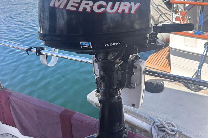 Slide: The Image of Outboard motor on a 1978 Tayana Mariner sailboat, docked by the water. - 39