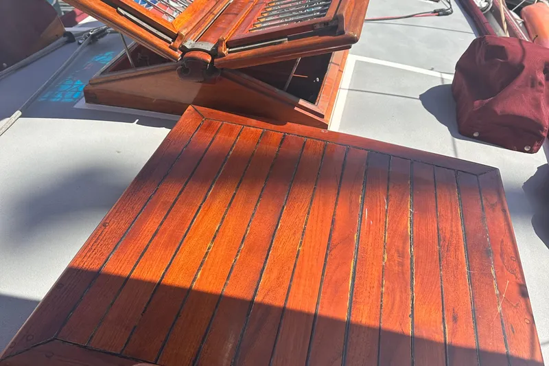 Slide: The Image of Polished wooden deck of a 1978 Tayana Mariner sailboat, featuring open hatch. - 4