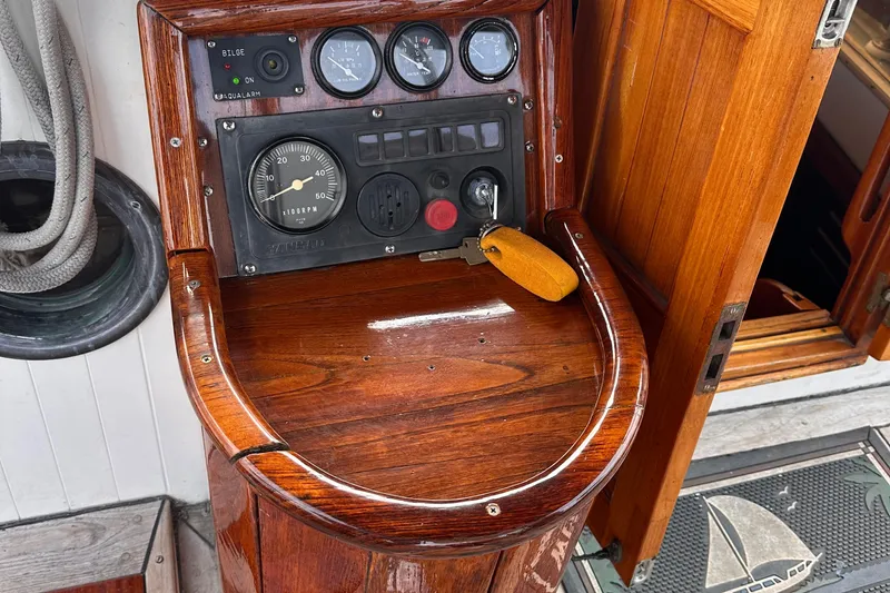 Slide: The Image of 1978 Tayana Mariner boat dashboard with wooden finish and nautical instruments. - 6