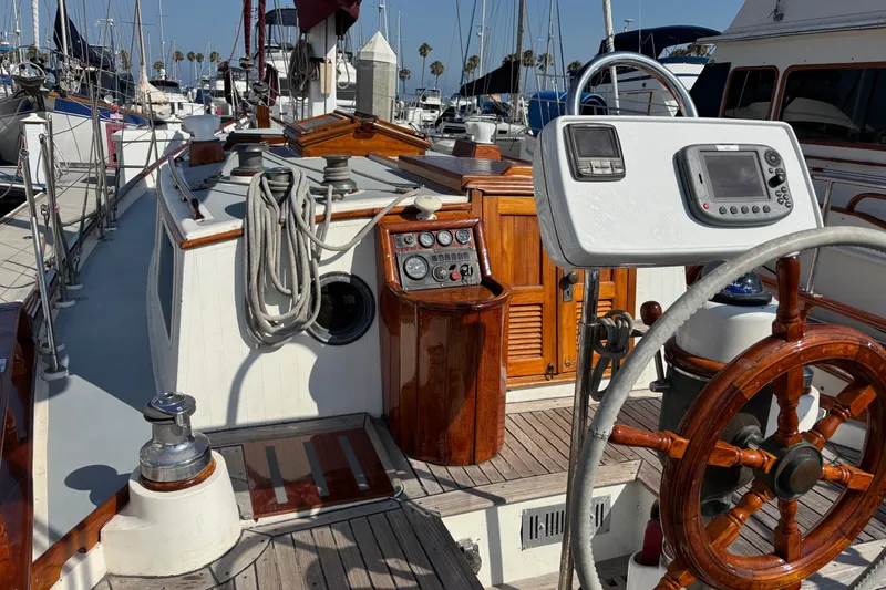 Slide: The Image of 1978 Tayana Mariner sailboat cockpit with wooden wheel and navigation equipment. - 8