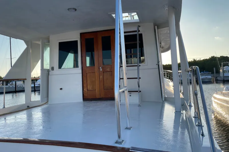 Slide: The Image of 1973 Hatteras 58 Yacht Fisherman deck with wooden doors and marina view. - 12