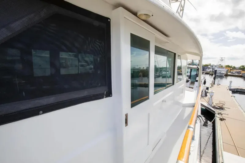 Slide: The Image of 1973 Hatteras 58 Yacht Fisherman docked, showcasing side view and windows. - 16