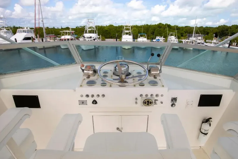 Slide: The Image of 1973 Hatteras 58 Yacht Fisherman helm with steering wheel and controls, docked at marina. - 21