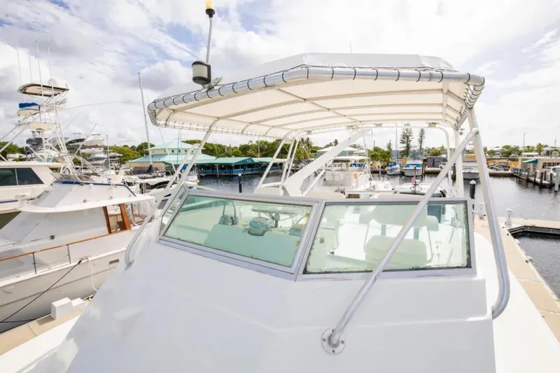 Slide: The Image of 1973 Hatteras 58 Yacht Fisherman docked at marina under cloudy sky. - 23