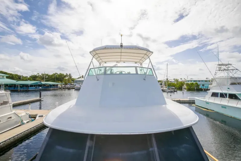 Slide: The Image of 1973 Hatteras 58 Yacht Fisherman docked in a sunny marina setting. - 26