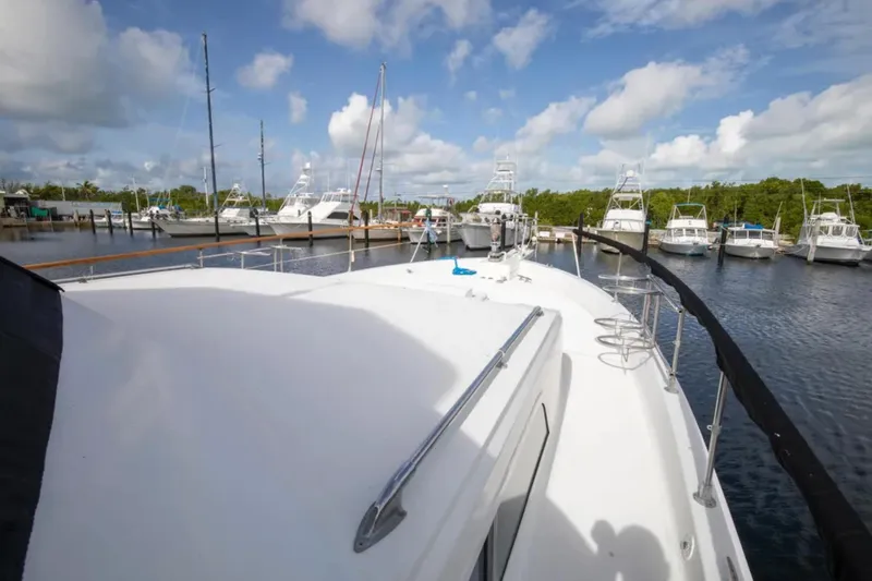 Slide: The Image of 1973 Hatteras 58 Yacht Fisherman docked at a marina under a blue sky. - 27