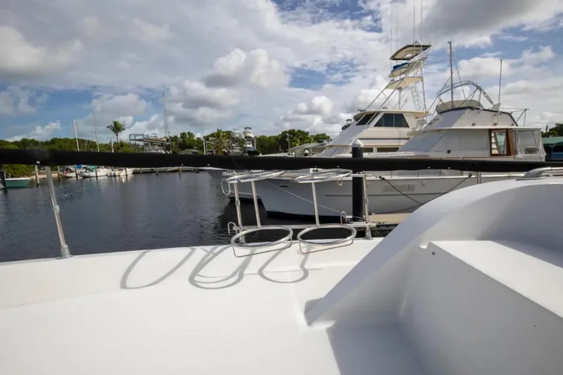 Slide: The Image of 1973 Hatteras 58 Yacht Fisherman docked at marina under cloudy sky. - 29
