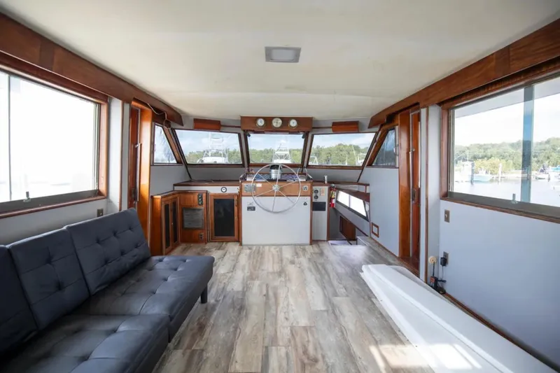Slide: The Image of 1973 Hatteras 58 Yacht Fisherman interior with helm, wood accents, and large windows. - 31