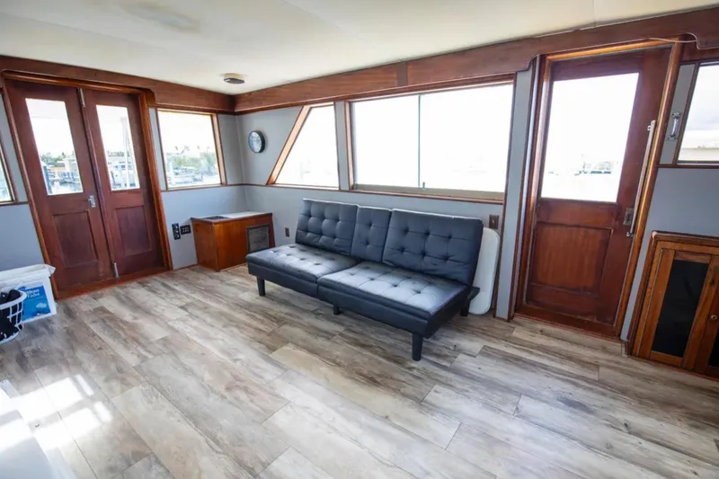 Slide: The Image of 1973 Hatteras 58 Yacht Fisherman interior with wooden floors and modern black sofa. - 34