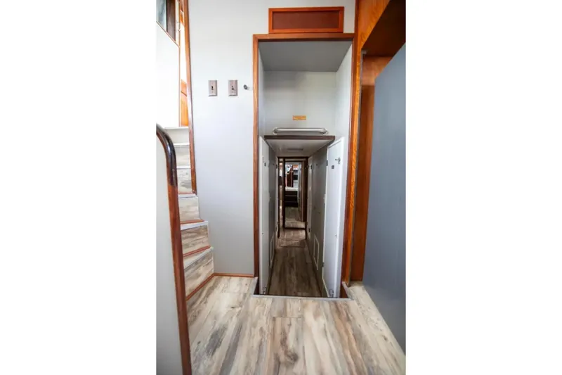 Slide: The Image of Interior hallway of a 1973 Hatteras 58 Yacht Fisherman, featuring wood accents and stairs. - 42