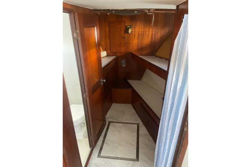 Slide: The Image of 1973 Hatteras 58 Yacht Fisherman interior with wood paneling and compact bathroom. - 43