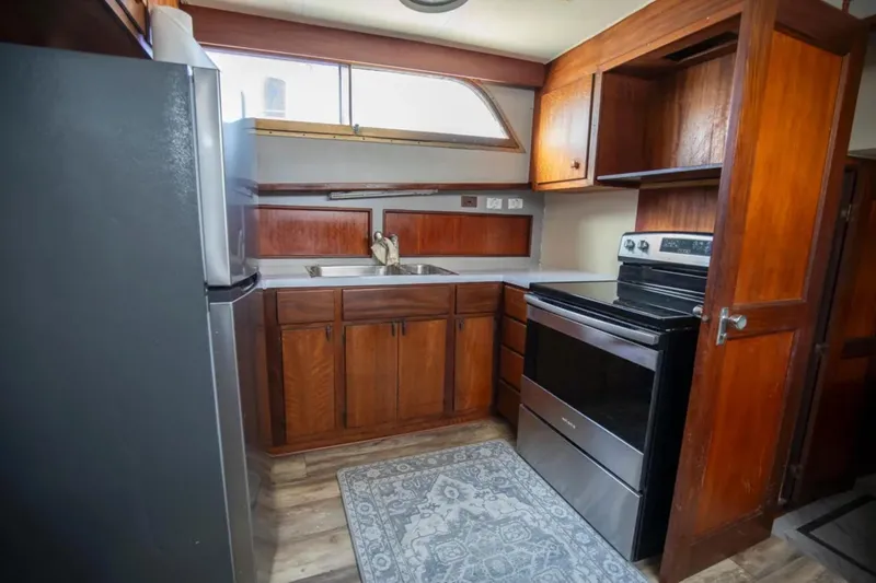 Slide: The Image of 1973 Hatteras 58 Yacht Fisherman kitchen with wood cabinets and modern appliances. - 44