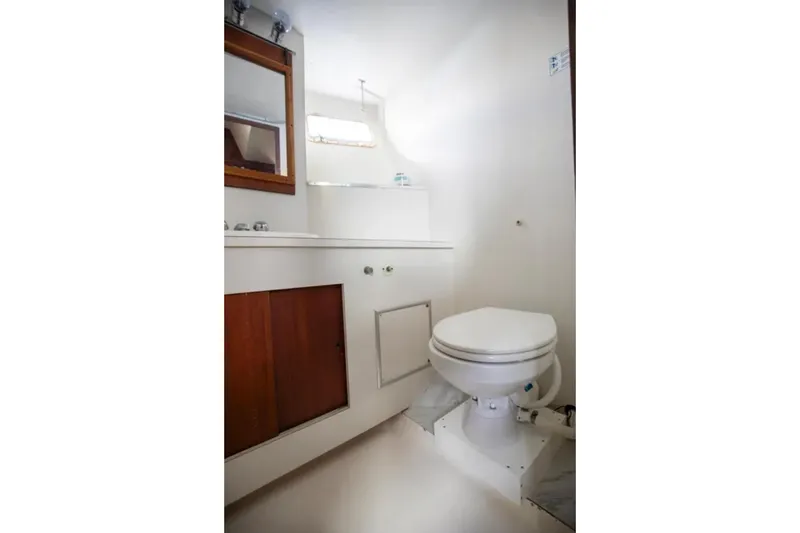 Slide: The Image of Bathroom interior of 1973 Hatteras 58 Yacht Fisherman, featuring toilet and wooden cabinetry. - 51