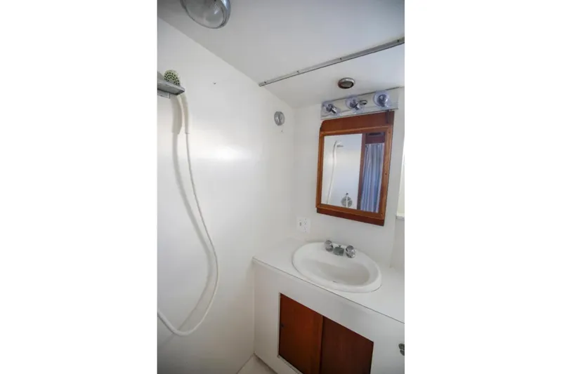 Slide: The Image of 1973 Hatteras 58 Yacht Fisherman bathroom with shower, sink, and mirror. - 52
