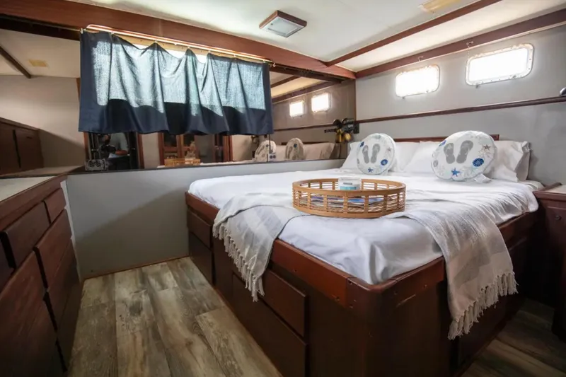 Slide: The Image of 1973 Hatteras 58 Yacht Fisherman cabin with cozy bed, wooden accents, and nautical decor. - 53
