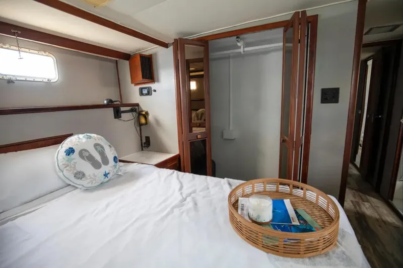 Slide: The Image of 1973 Hatteras 58 Yacht Fisherman cabin interior with bed, window, and wicker tray. - 56