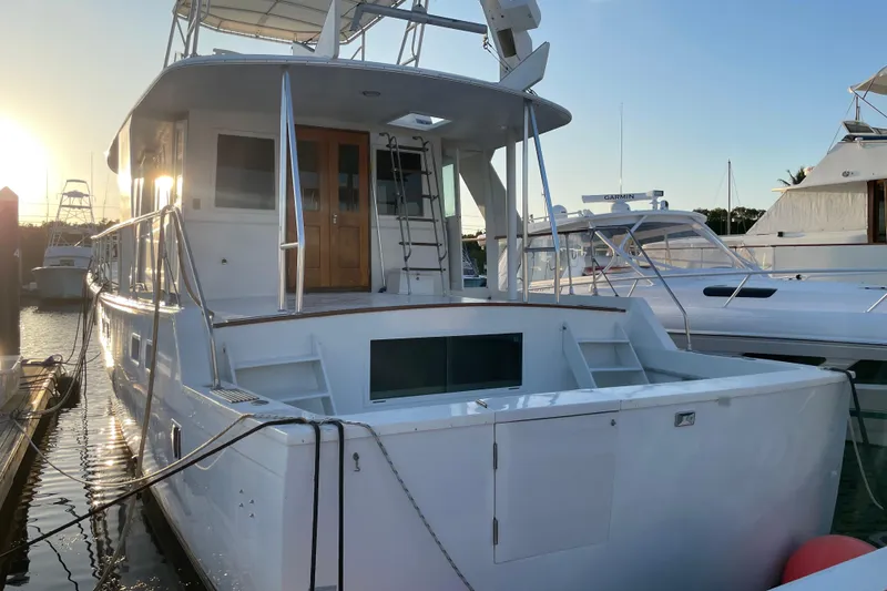 Slide: The Image of 1973 Hatteras 58 Yacht Fisherman docked at sunset, showcasing elegant design. - 6
