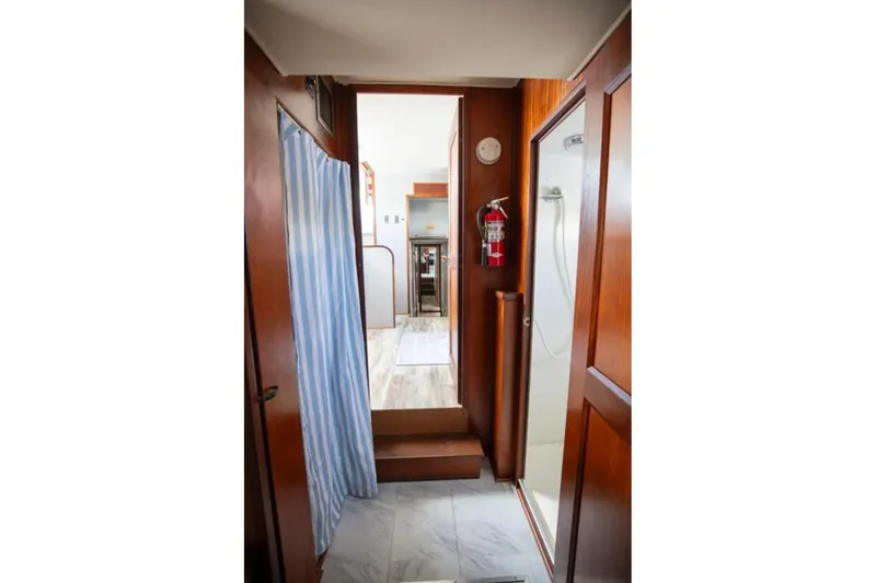 Slide: The Image of Interior of 1973 Hatteras 58 Yacht Fisherman with wood paneling and a fire extinguisher. - 60