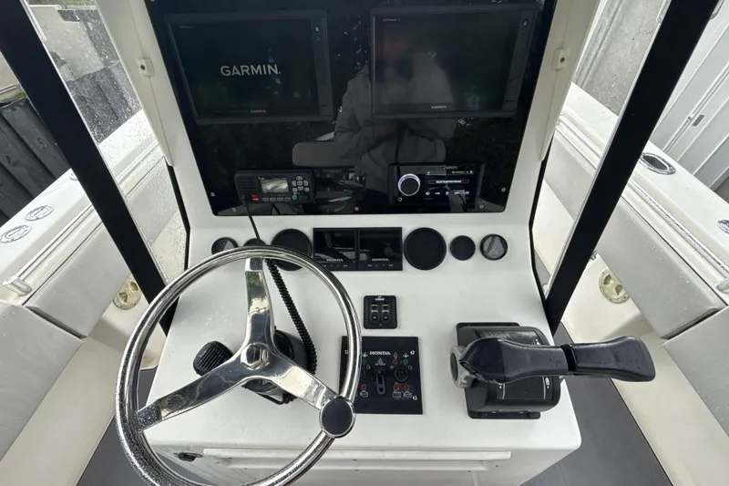 Slide: The Image of 2005 Contender 27 Open boat dashboard with Garmin navigation system and steering wheel. - 12